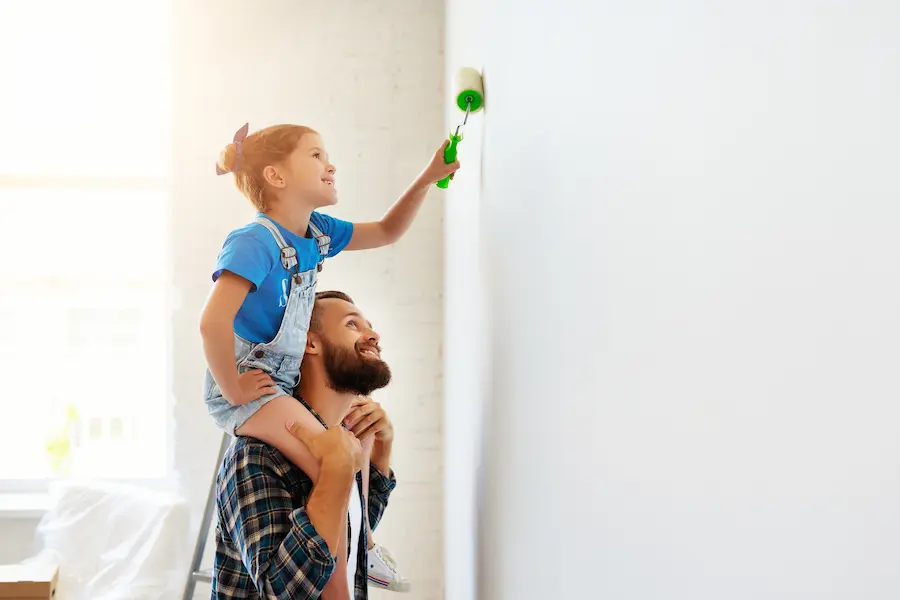 Daught on dad's shoulders painting wall